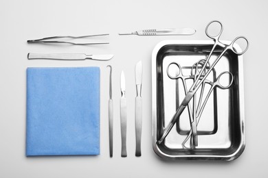 Photo of Different surgical tools on light gray background, flat lay