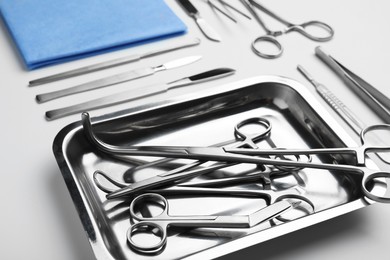 Photo of Different surgical tools on light gray background, closeup