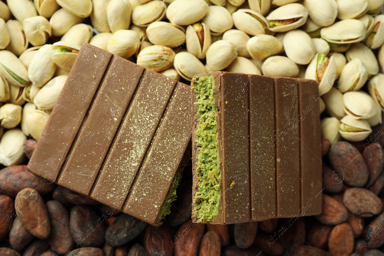 Photo of Pieces of tasty Dubai chocolate with knafeh, pistachios and cocoa beans, top view