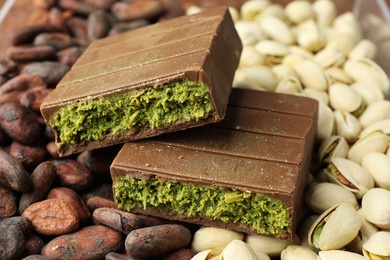 Photo of Pieces of tasty Dubai chocolate with knafeh, pistachios and cocoa beans, closeup