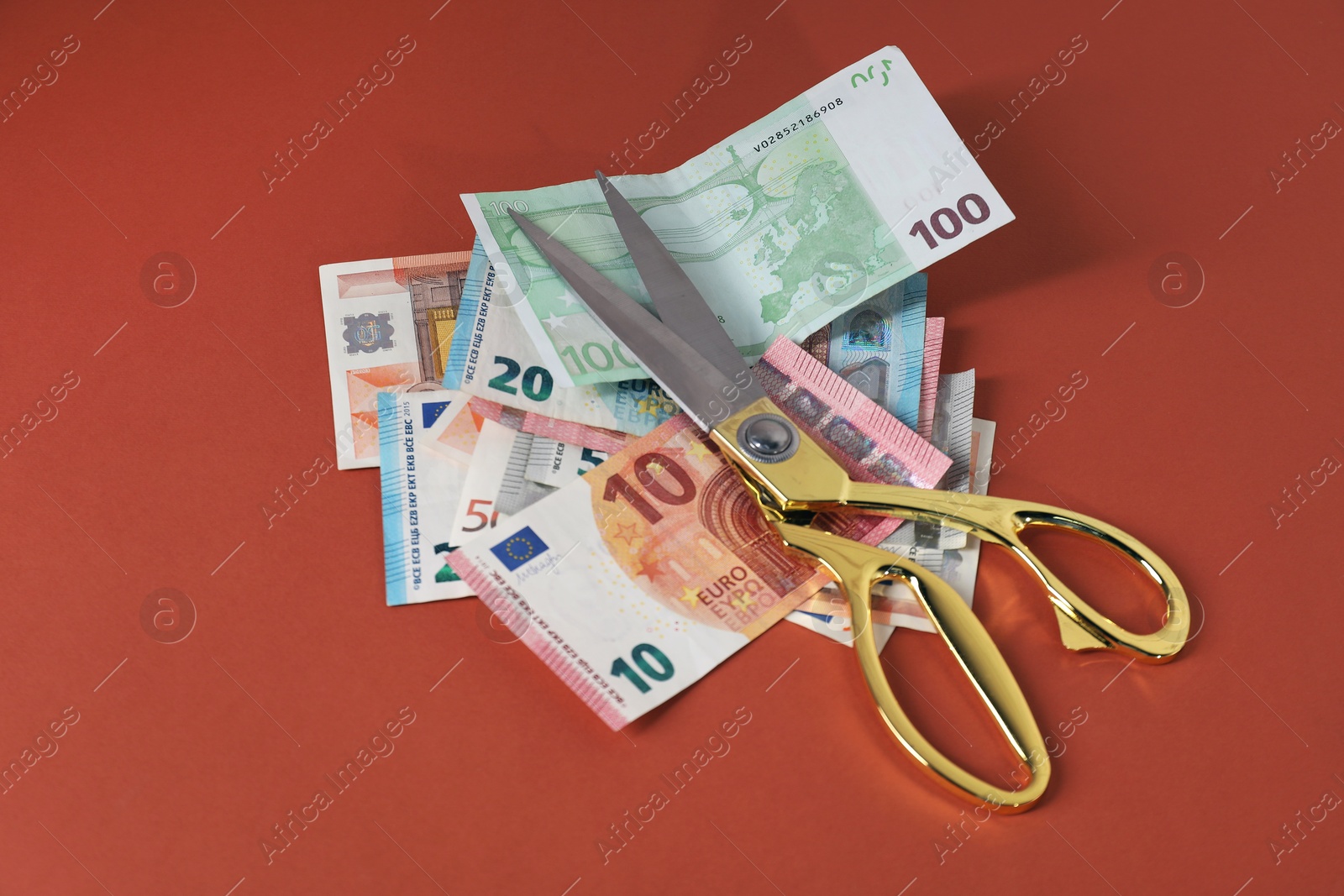 Photo of Euro banknotes and scissors on brown background