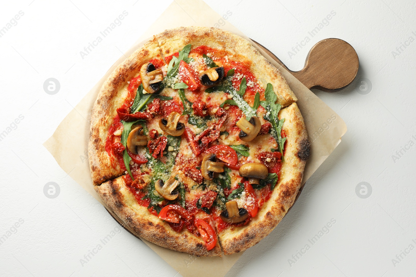 Photo of Tasty pizza with mushrooms, tomatoes and arugula on white table, top view