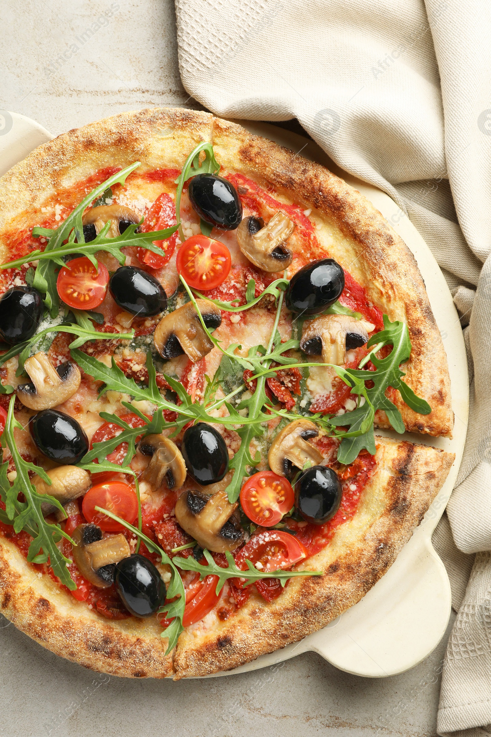 Photo of Tasty pizza with mushrooms, olives and arugula on light grey table, top view