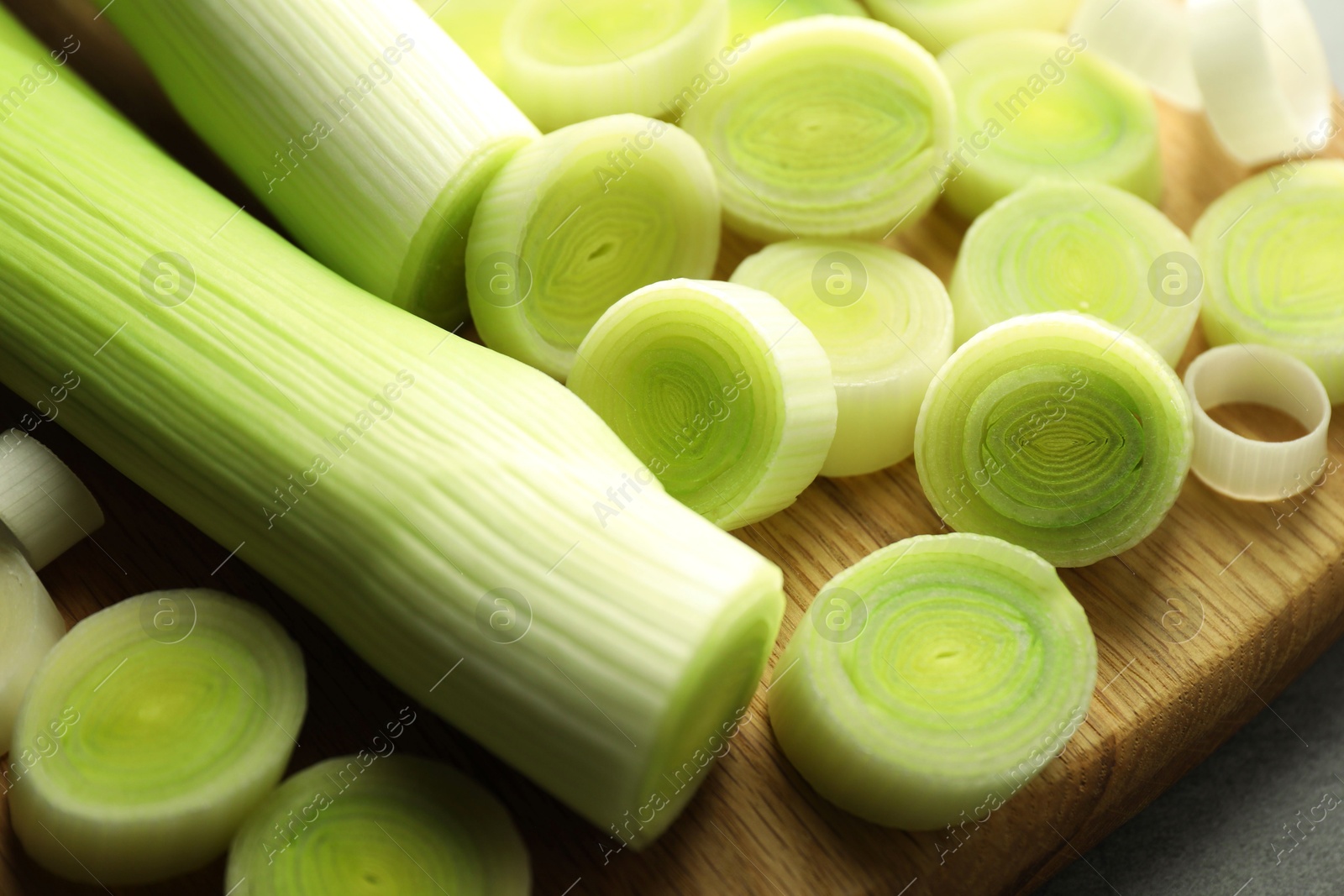 Photo of Fresh cut leeks on grey table, closeup