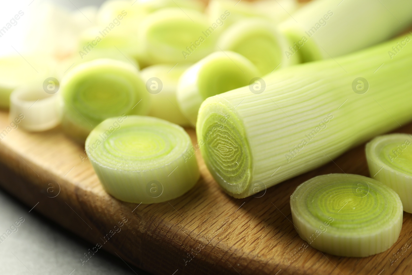 Photo of Fresh cut leeks on grey table, closeup