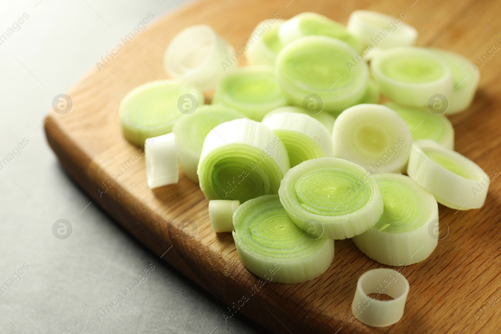 Photo of Fresh cut leeks on grey table, closeup