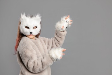 Photo of Quadrobics. Girl wearing cat mask and gloves on grey background, space for text