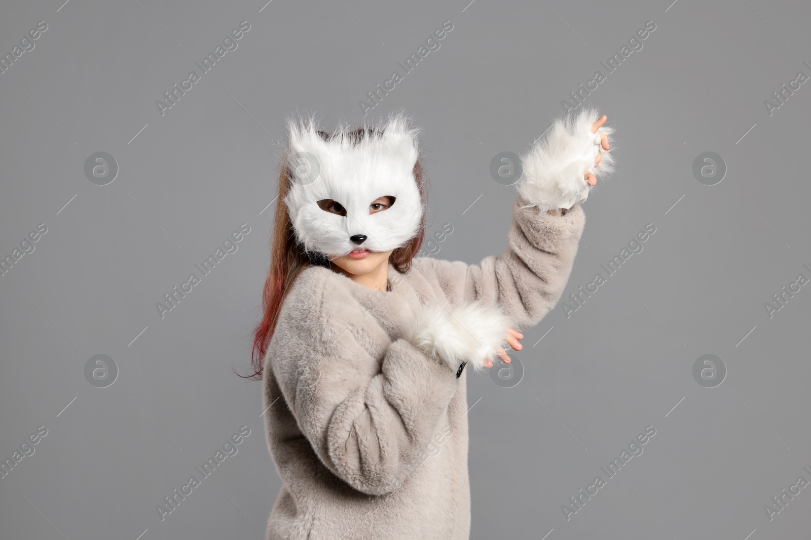 Photo of Quadrobics. Girl wearing cat mask and gloves on grey background