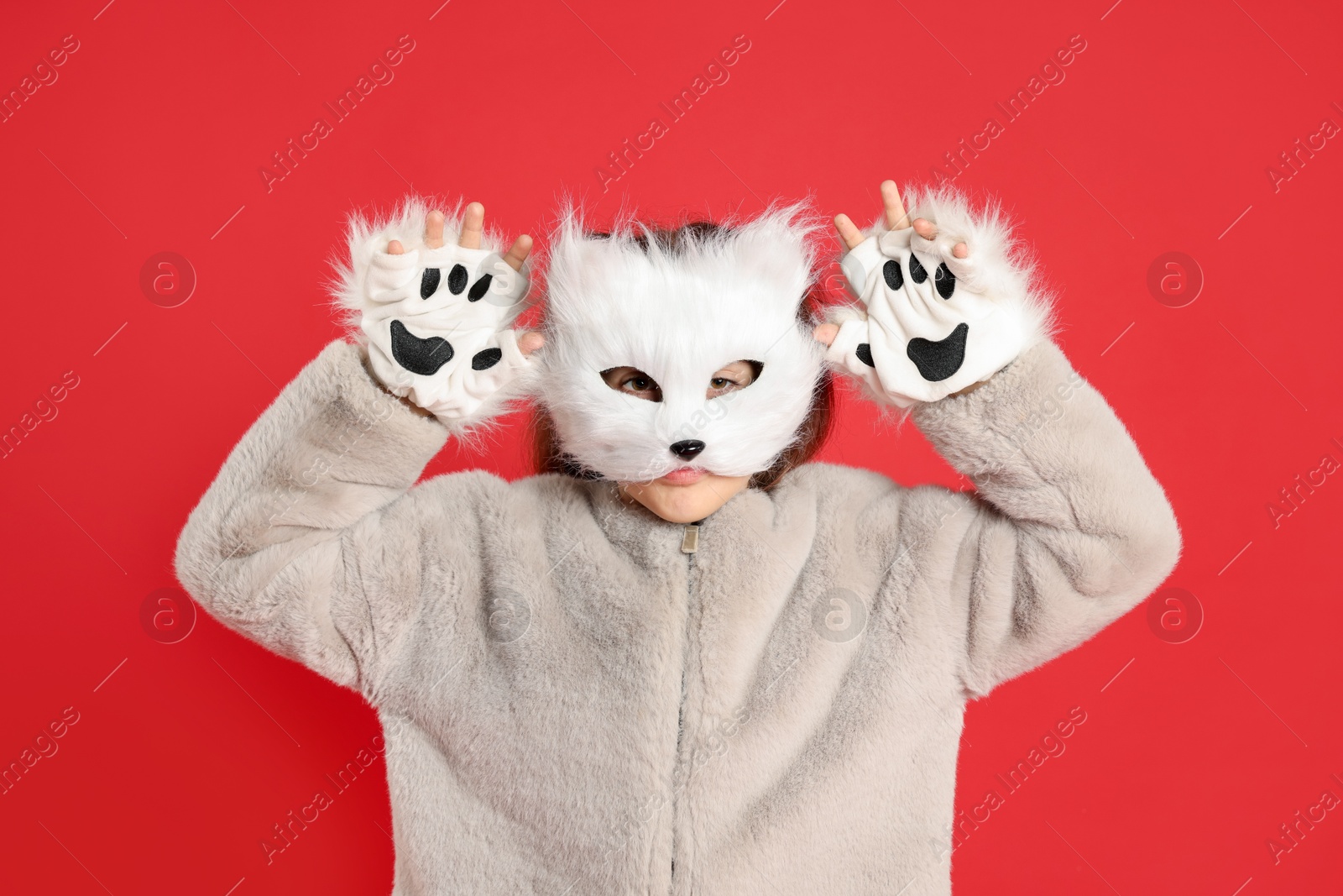 Photo of Quadrobics. Girl wearing cat mask and gloves on red background