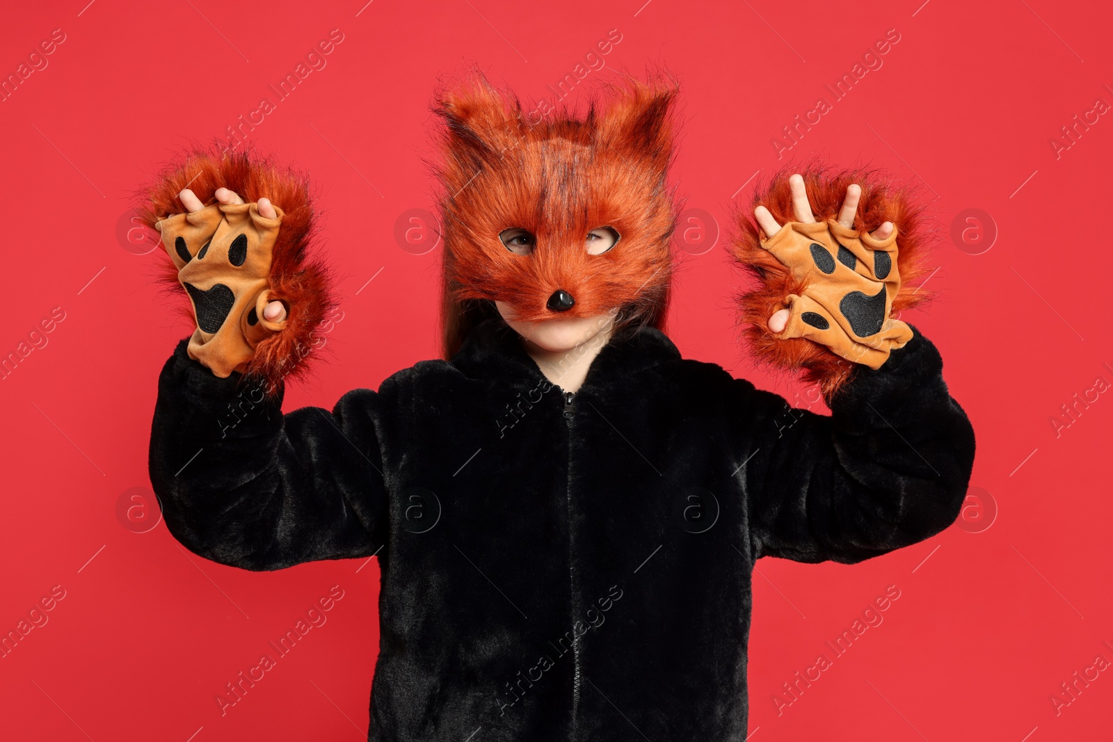 Photo of Quadrobics. Girl wearing fox mask and gloves on red background