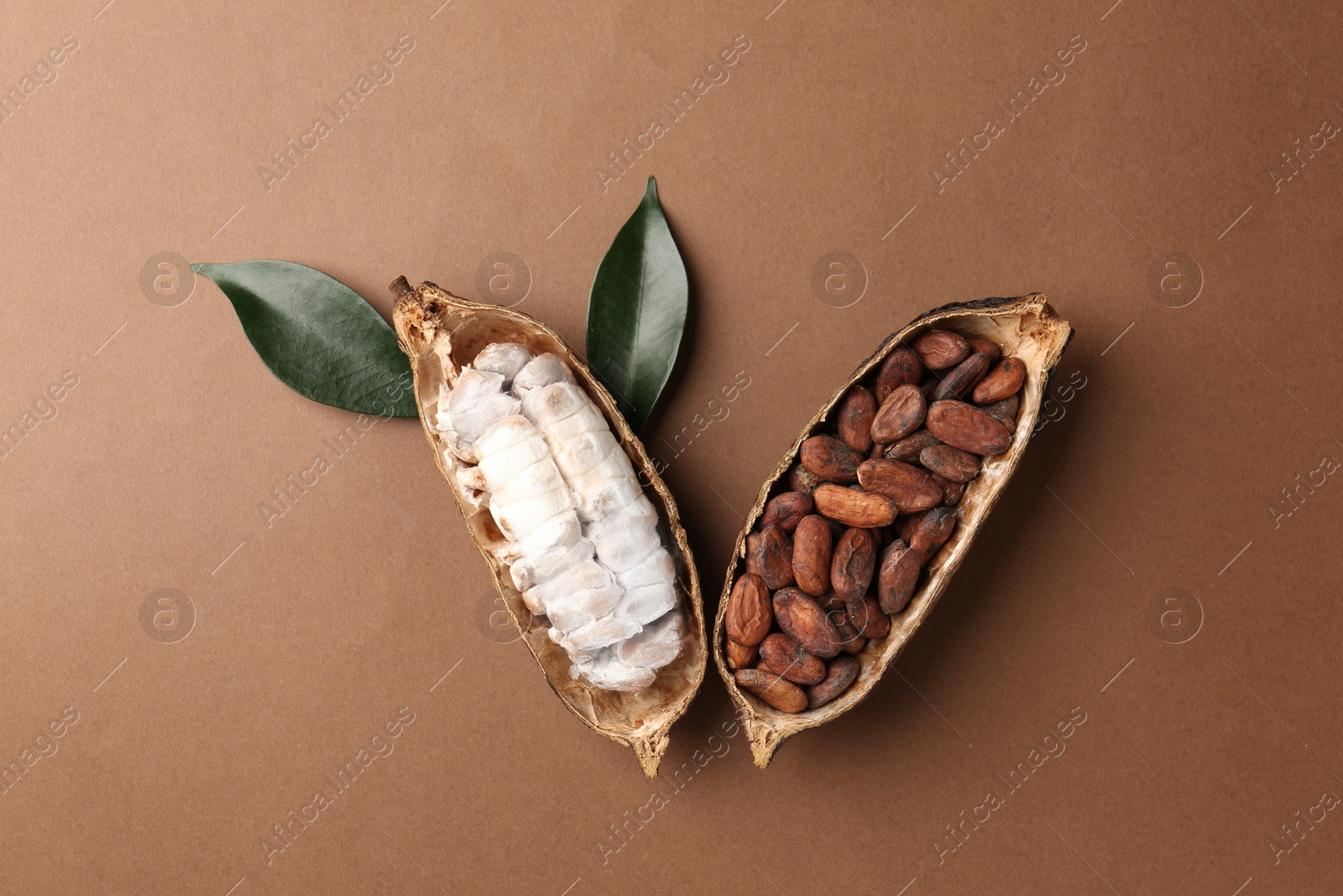 Cocoa pods with beans on brown background, top view Photo of Cocoa pods with beans on brown background, top view