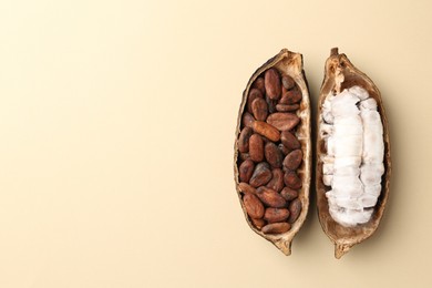 Photo of Cocoa pods with beans on beige background, top view. Space for text