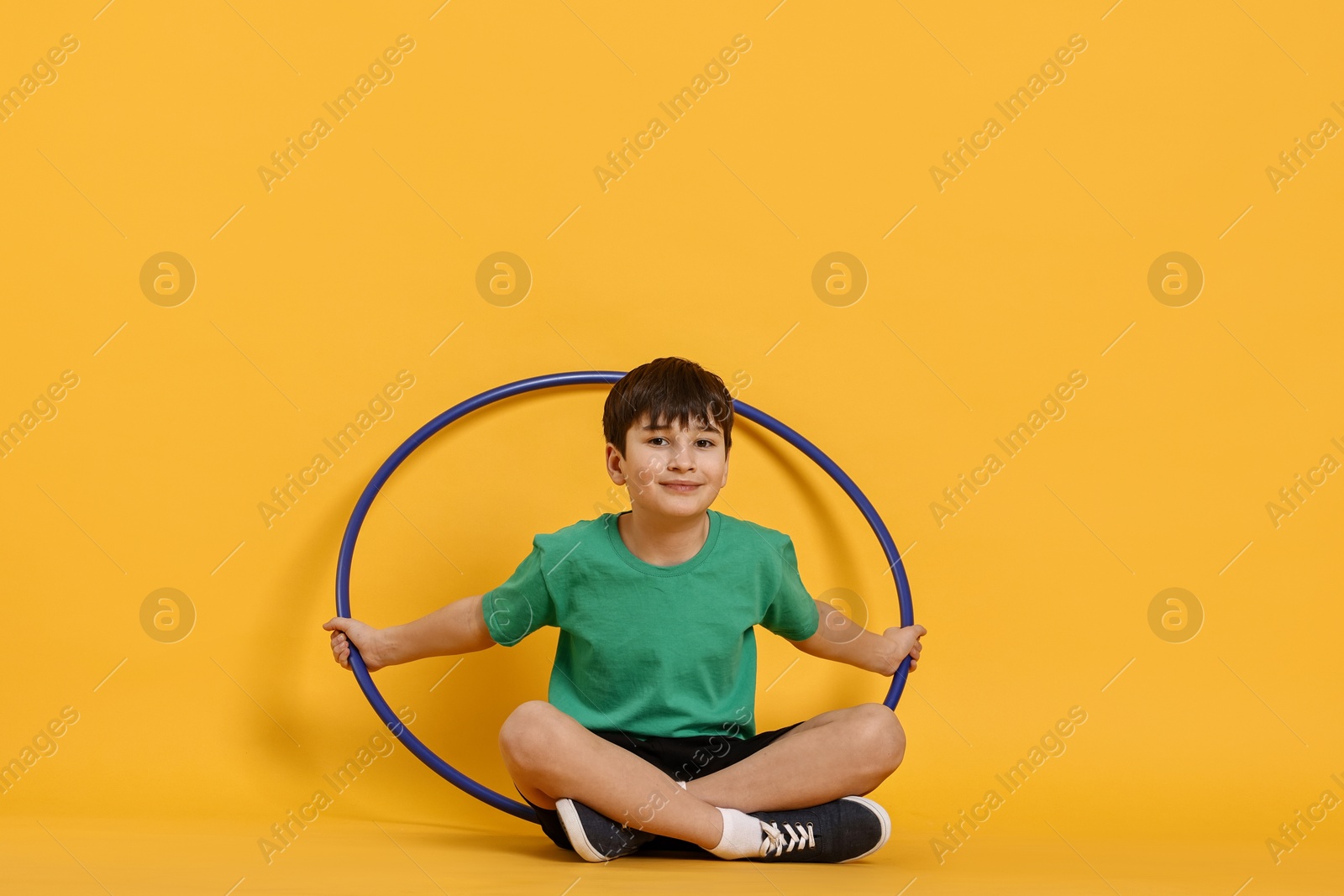 Photo of Boy with hula hoop on yellow background