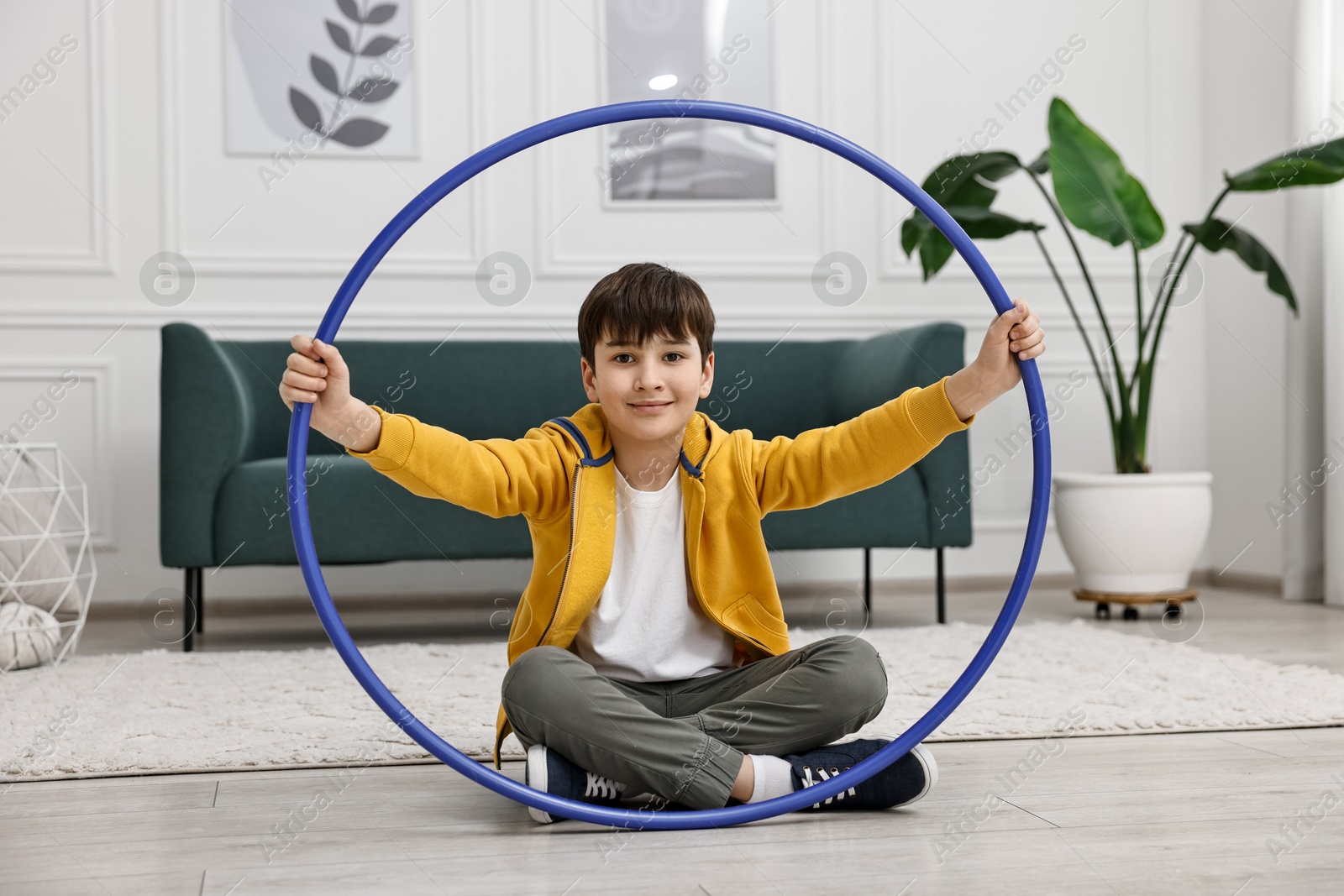 Photo of Boy with hula hoop on floor at home