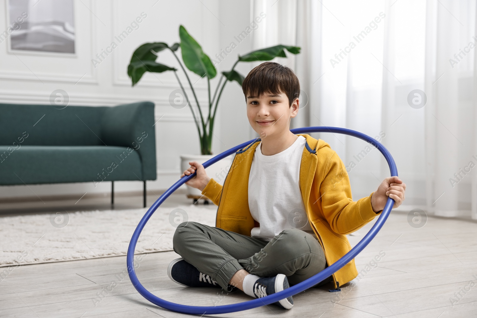 Photo of Boy with hula hoop on floor at home