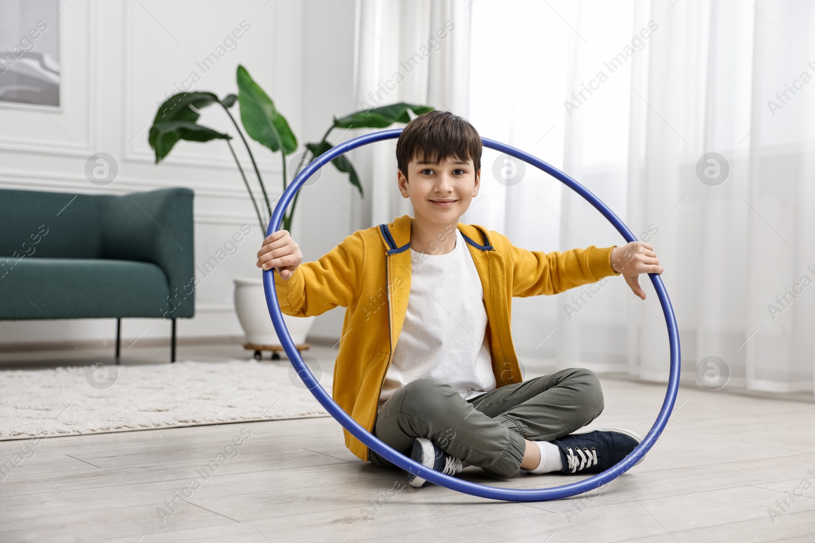 Photo of Boy with hula hoop on floor at home