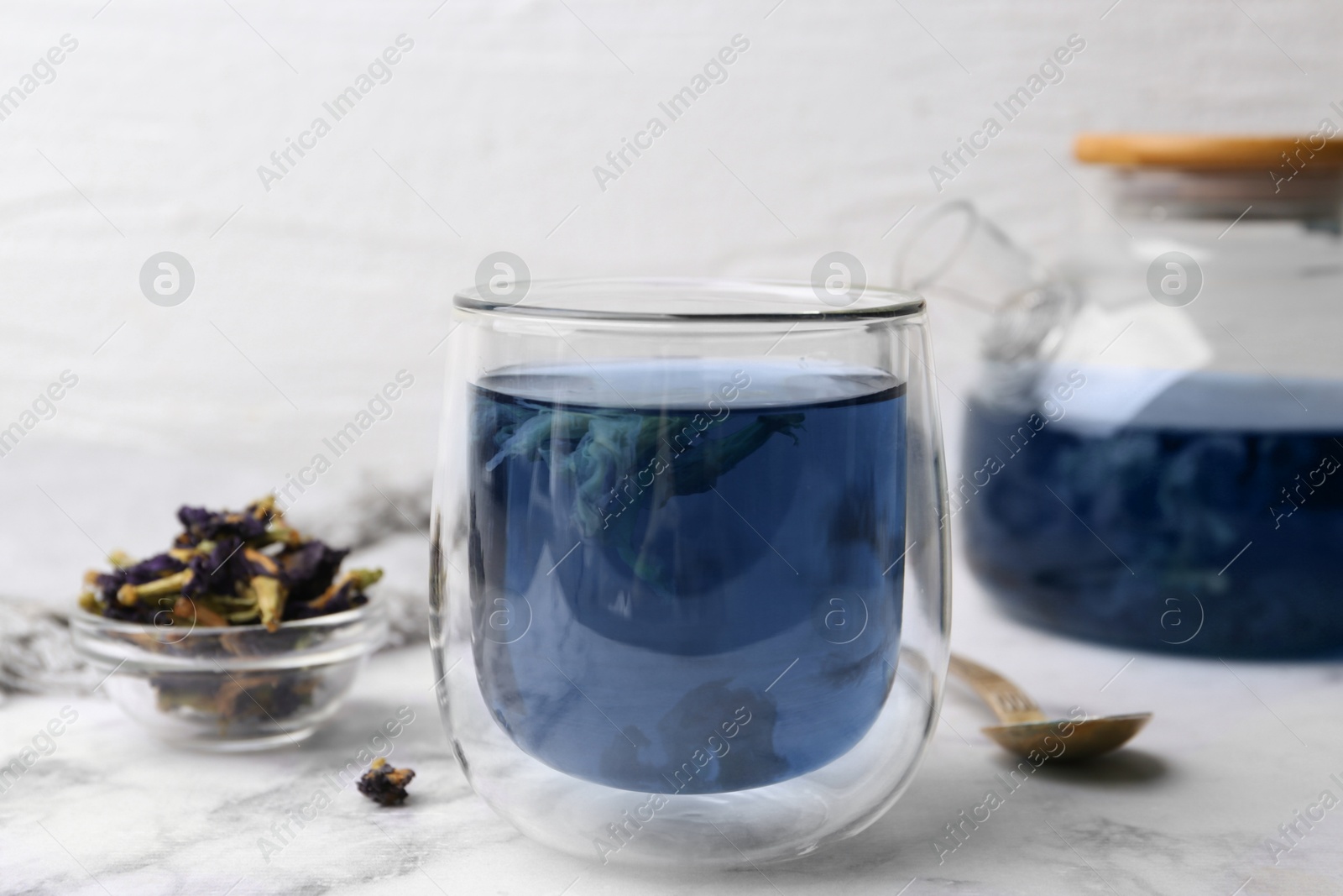 Delicious butterfly pea flower tea on white marble table Photo of Delicious butterfly pea flower tea on white marble table