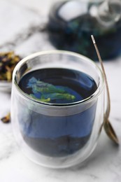 Photo of Delicious butterfly pea flower tea on white marble table, closeup