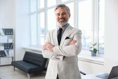 Photo of Happy banker with crossed arms in office