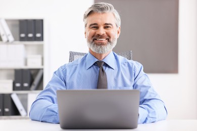 Banker working on laptop at desk in office