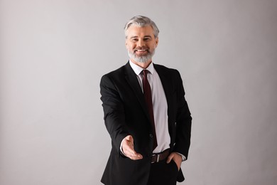 Portrait of happy banker on grey background