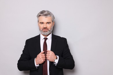 Photo of Portrait of banker in jacket on grey background, space for text