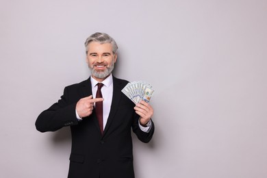 Photo of Banker with dollar banknotes on grey background, space for text