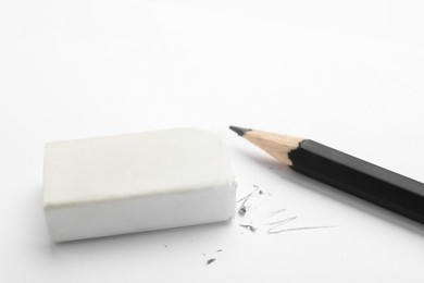 Photo of Eraser and pencil on white background, closeup