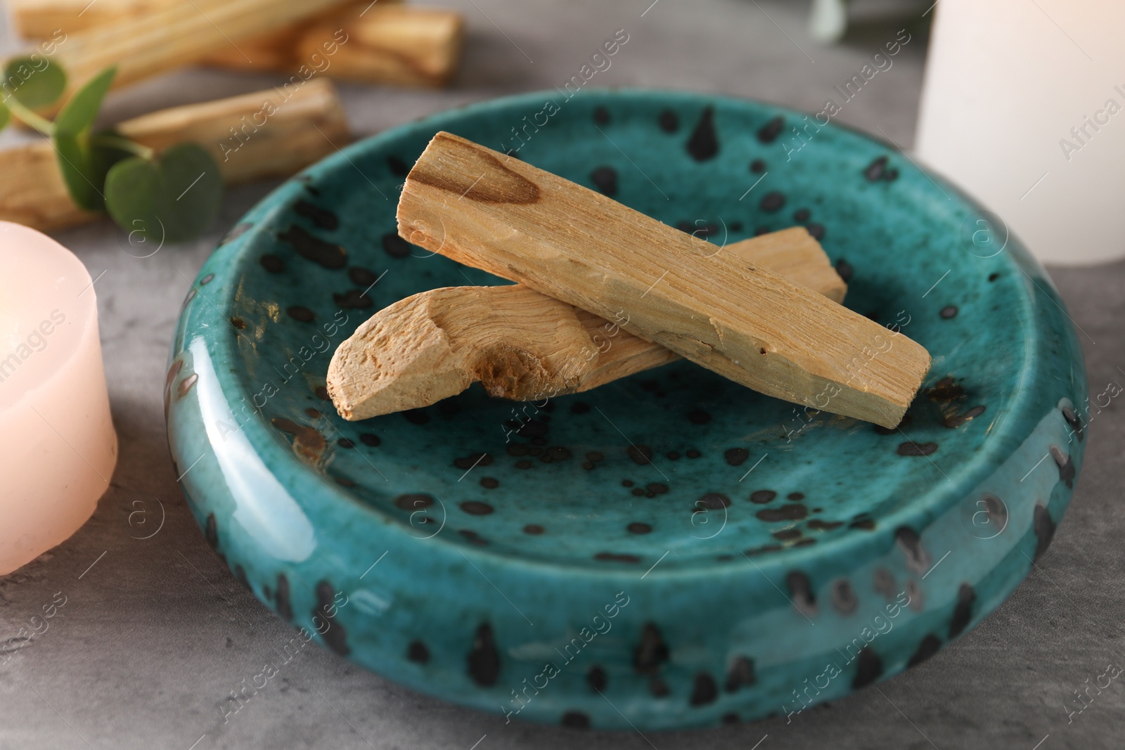 Photo of Palo santo sticks on grey table, closeup