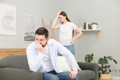 Photo of Resentful couple arguing at home, selective focus