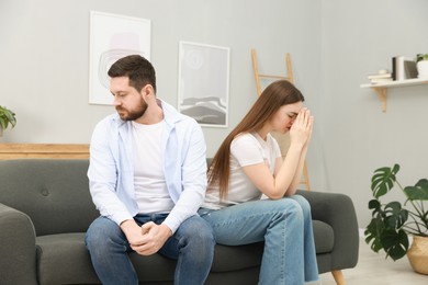 Photo of Resentful couple sitting on couch at home