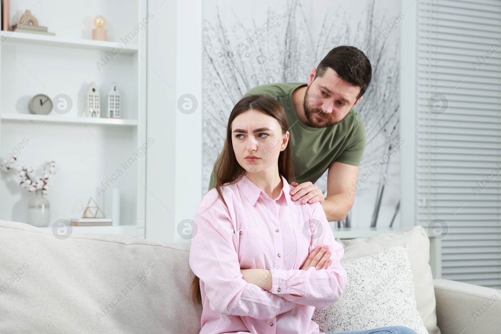 Photo of Man comforting his resentful girlfriend at home. . Relationship problem