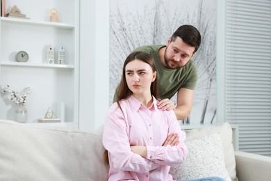 Photo of Man comforting his resentful girlfriend at home. . Relationship problem