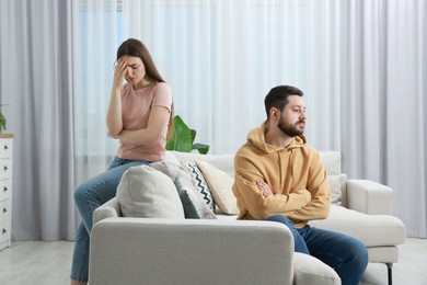 Photo of Resentful couple in living room. Relationship problem