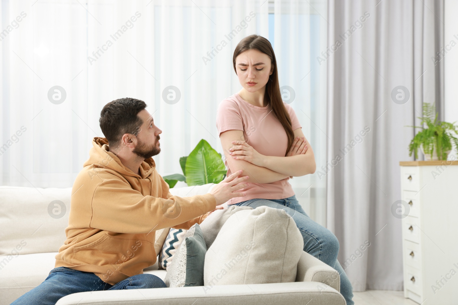 Photo of Man comforting his resentful girlfriend at home