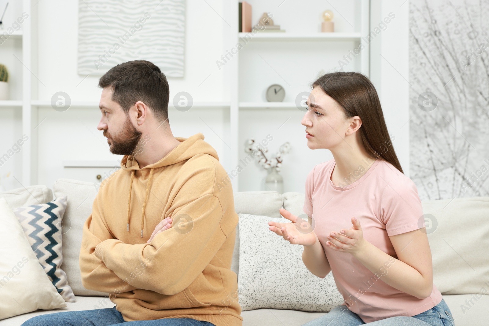 Photo of Angry couple arguing on couch at home