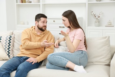 Angry couple arguing on couch at home