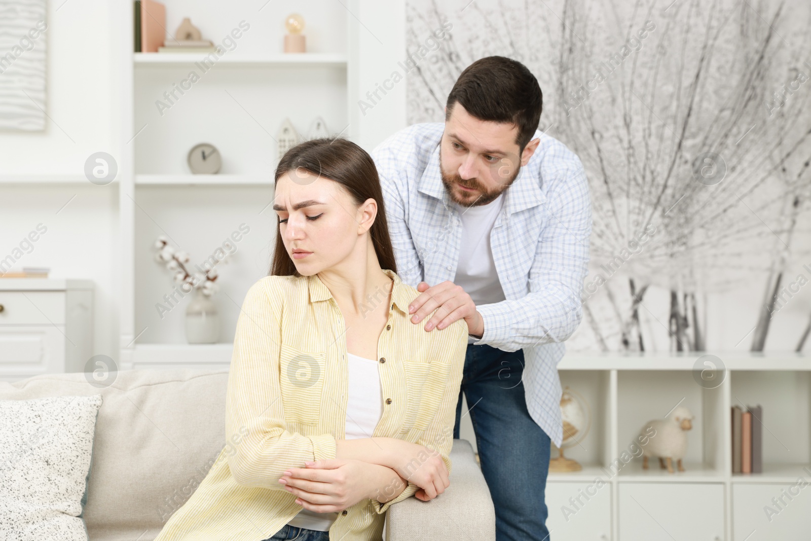 Photo of Man comforting his resentful girlfriend at home