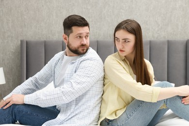 Photo of Resentful couple sitting on bed at home. Relationship problem