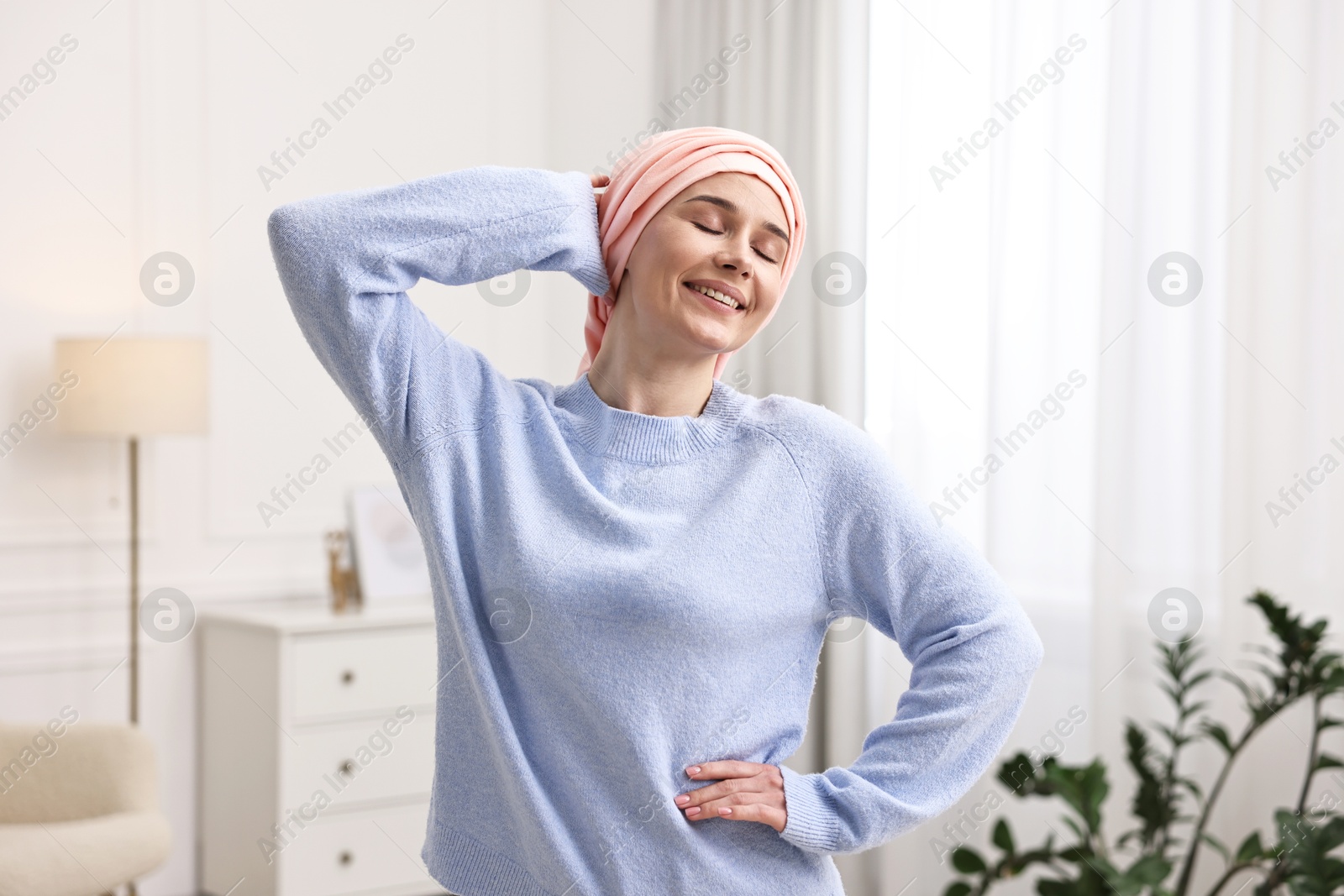 Photo of Portrait of smiling woman with cancer in headscarf indoors