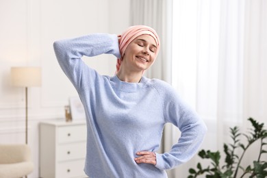 Photo of Portrait of smiling woman with cancer in headscarf indoors