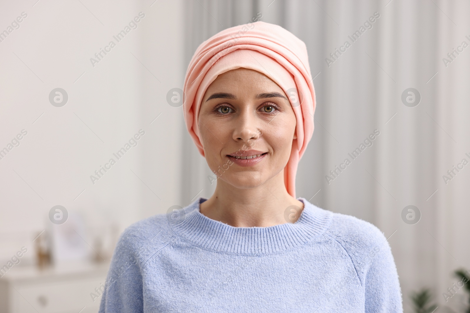 Photo of Portrait of smiling woman with cancer in headscarf indoors