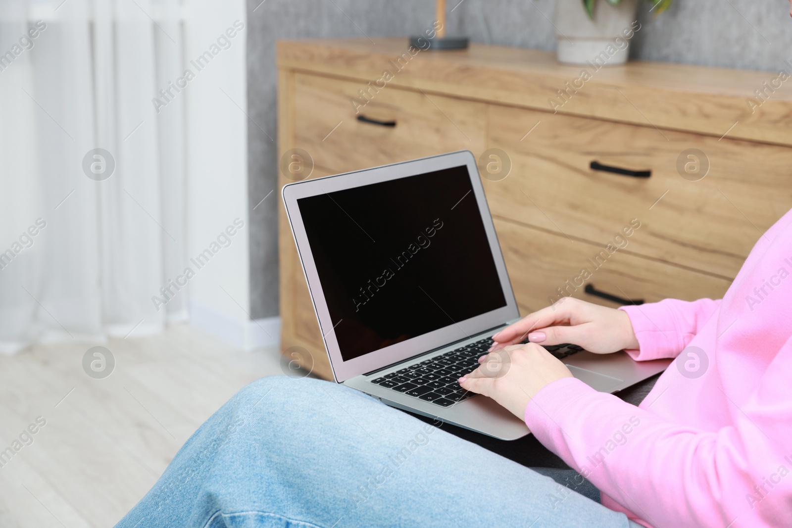 Photo of Woman working on laptop at home, closeup