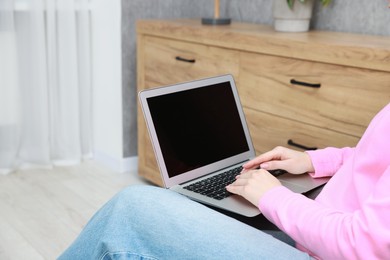 Photo of Woman working on laptop at home, closeup