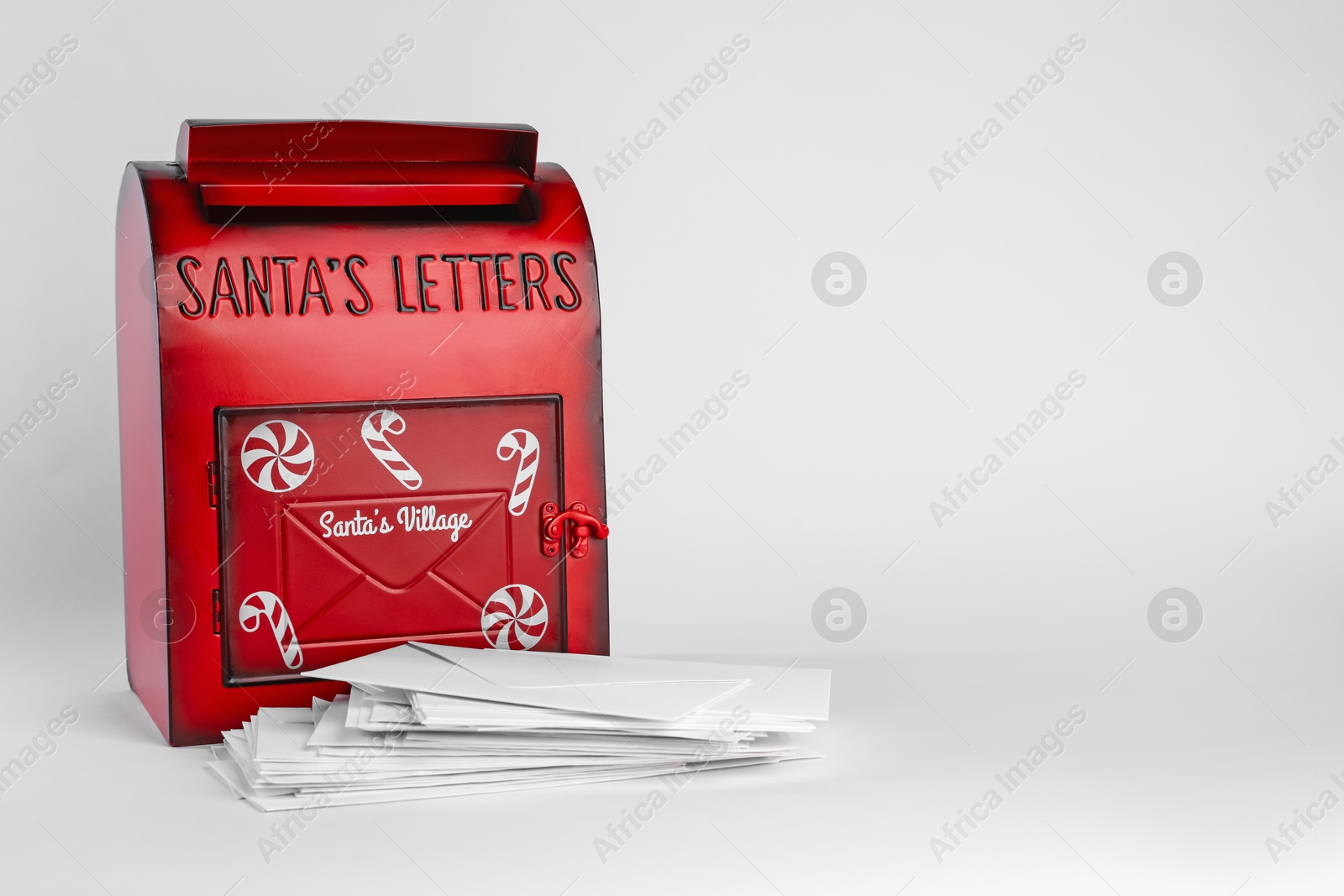 Photo of Santa Claus mail box and letters on white background, space for text. Christmas tradition