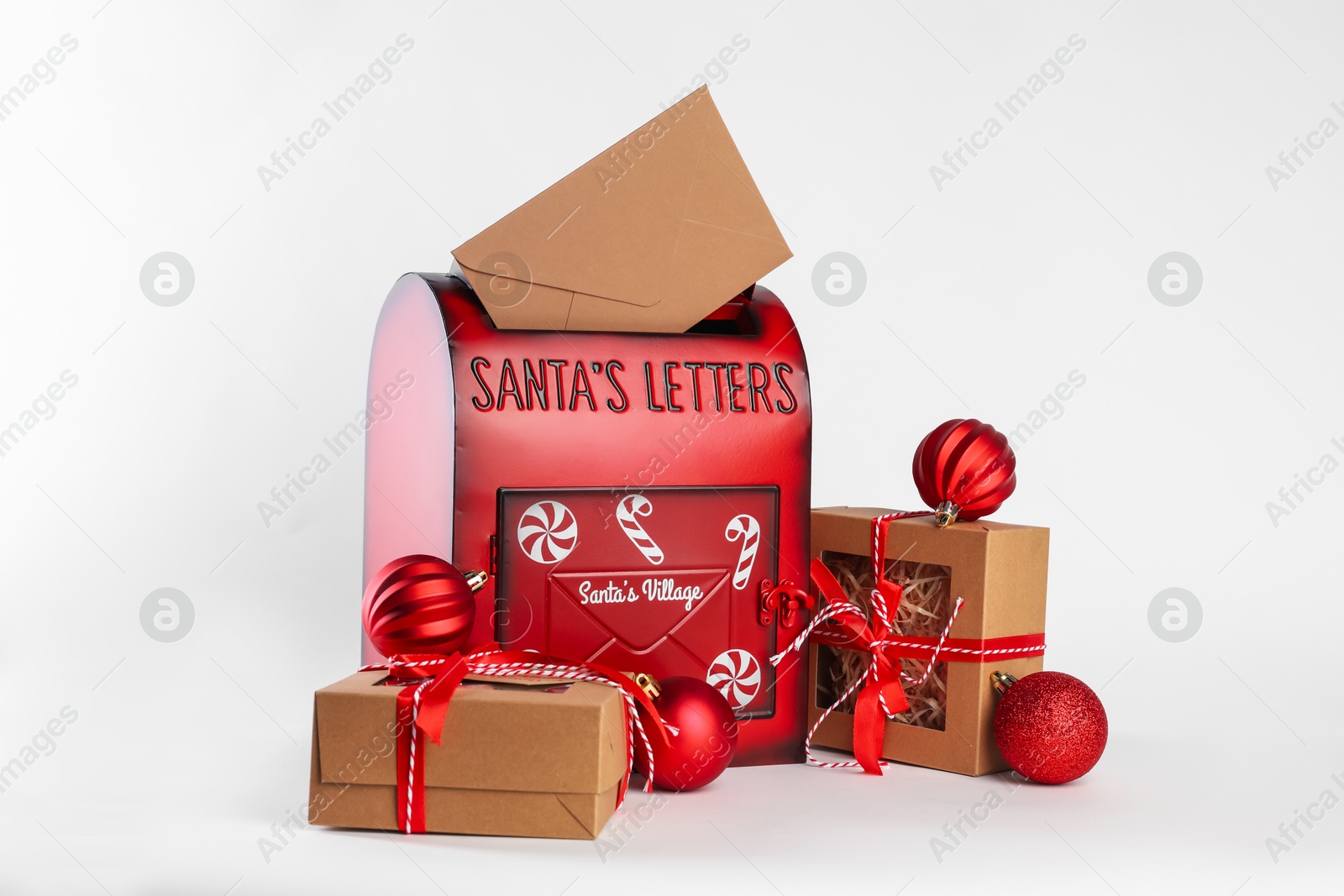 Photo of Santa Claus mail box with letter, gifts and Christmas baubles on white background