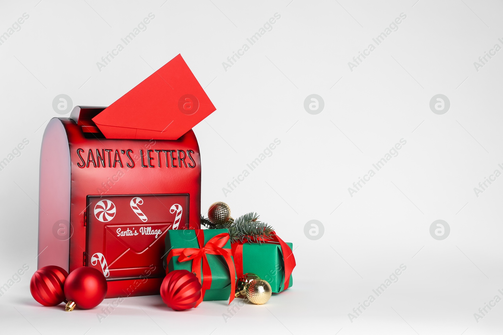 Photo of Santa Claus mail box with letter, gifts and Christmas decor on white background, space for text