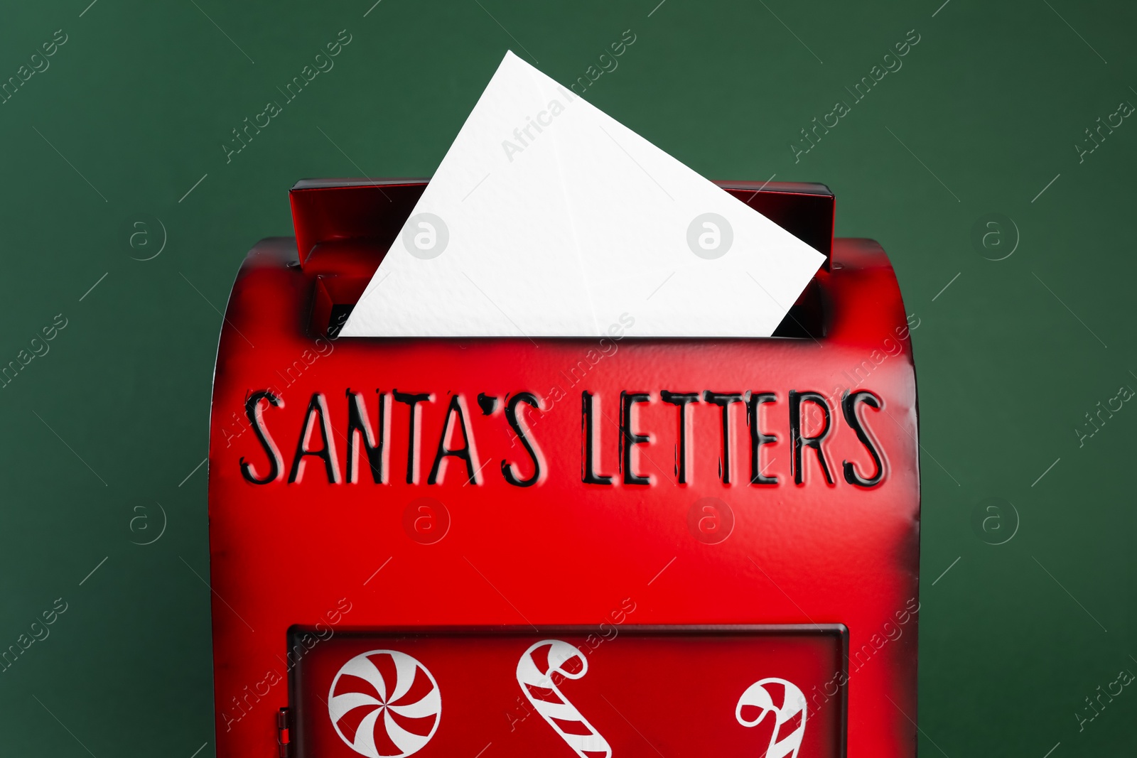 Photo of Santa Claus mail box with letter on dark green background, closeup. Christmas tradition