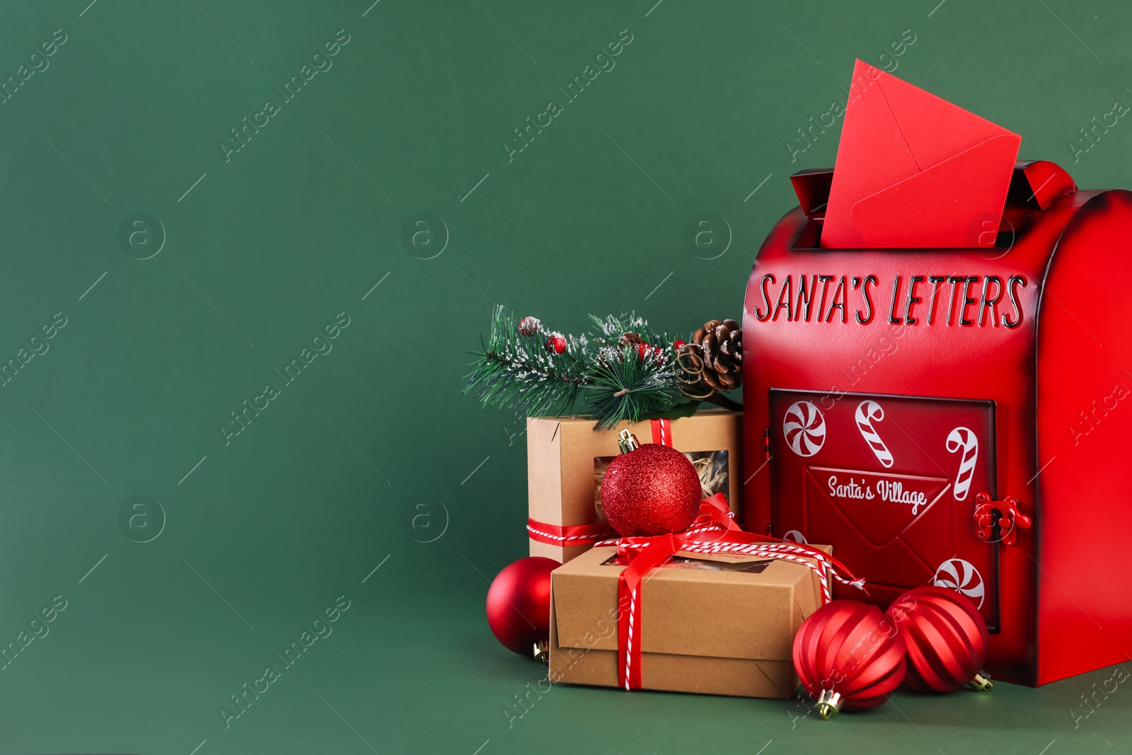 Photo of Santa Claus mail box with letter, gifts and Christmas decor on dark green background, space for text