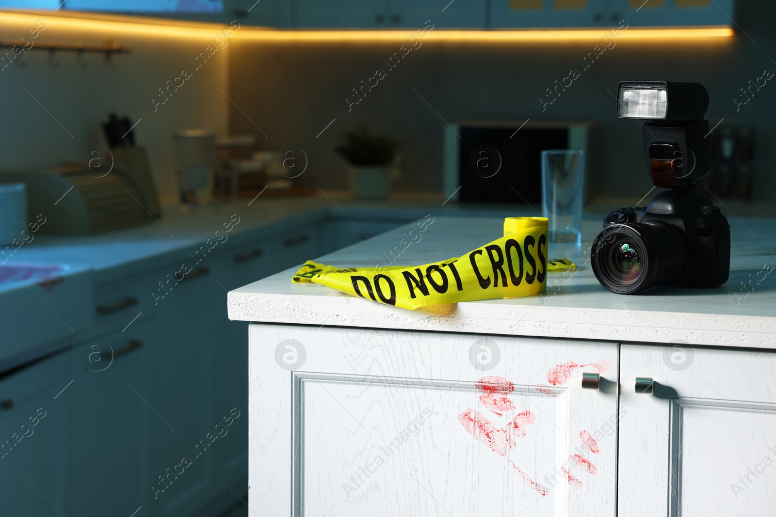 Photo of Camera, yellow crime scene tape and bloody handprint on chest of drawers in kitchen. Forensic expertise